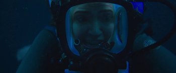 Movie still from “47 Meters Down” (2017), directed by Johannes Roberts – A person wearing a scuba mask in the dark; Close Up shot, Over the shoulder angle