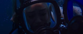 Movie still from “47 Meters Down” (2017), directed by Johannes Roberts – A person wearing a diving suit in the dark; Close Up shot, Overhead angle