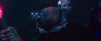 Movie still from “47 Meters Down” (2017), directed by Johannes Roberts – A person wearing a diving suit and a helmet underwater; Medium shot, High angle