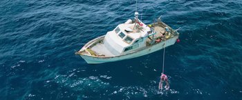 Movie still from “47 Meters Down” (2017), directed by Johannes Roberts – A man is on a boat in the water; Extreme Wide shot, Overhead angle