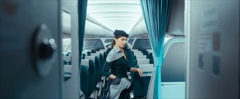 Movie still from “7500” (2019), directed by Patrick Vollrath – A woman is walking down the aisle of an airplane; Wide shot, Low angle