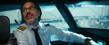 Movie still from “7500” (2019), directed by Patrick Vollrath – A man wearing a pilot's uniform sitting in a car; Close Up shot, Low angle