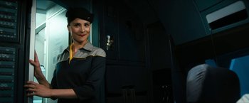 Movie still from “7500” (2019), directed by Patrick Vollrath – A woman standing in front of a door wearing a hat; Medium shot, Overhead angle