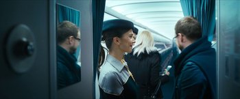 Movie still from “7500” (2019), directed by Patrick Vollrath – A woman wearing a hat standing on a train; Medium shot, Over the shoulder angle