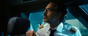 Movie still from “7500” (2019), directed by Patrick Vollrath – A man wearing a pilot's uniform sitting in a car; Close Up shot, Low angle
