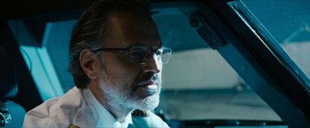 Movie still from “7500” (2019), directed by Patrick Vollrath – An older man wearing glasses sitting in a car; Close Up shot, Low angle