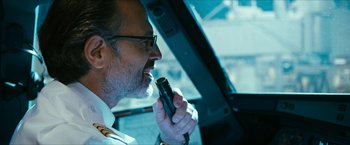 Movie still from “7500” (2019), directed by Patrick Vollrath – A person in a car holding a microphone; Close Up shot, Over the shoulder angle