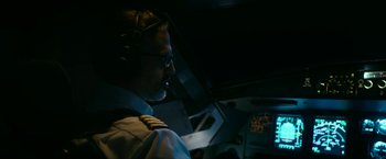 Movie still from “7500” (2019), directed by Patrick Vollrath – A man in a pilot's uniform is sitting in the cockpit of an airplane; Medium shot, Low angle