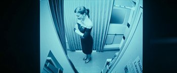 Movie still from “7500” (2019), directed by Patrick Vollrath – A woman standing in front of a mirror in a room; Medium shot, Overhead angle