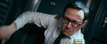 Movie still from “7500” (2019), directed by Patrick Vollrath – A man wearing a uniform and glasses is looking at the camera; Close Up shot, Low angle