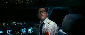 Movie still from “7500” (2019), directed by Patrick Vollrath – A man in a pilot's uniform looking at the camera; Close Up shot, High angle