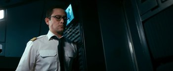 Movie still from “7500” (2019), directed by Patrick Vollrath – A man wearing a suit and tie standing in front of a computer; Close Up shot, Low angle