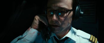 Movie still from “7500” (2019), directed by Patrick Vollrath – A man in glasses talking on a phone; Close Up shot, Overhead angle