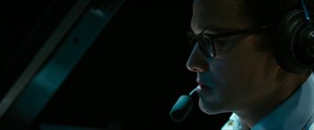 Movie still from “7500” (2019), directed by Patrick Vollrath – A man with glasses is holding a microphone in his mouth; Close Up shot, Low angle