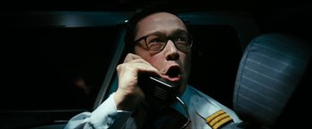 Movie still from “7500” (2019), directed by Patrick Vollrath – A man in glasses talking on a cell phone; Close Up shot, Low angle