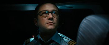 Movie still from “7500” (2019), directed by Patrick Vollrath – A man wearing glasses and a pilot's uniform; Close Up shot, Low angle