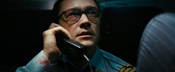 Movie still from “7500” (2019), directed by Patrick Vollrath – A man with glasses is talking on a cell phone; Close Up shot, Low angle