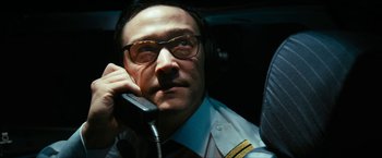 Movie still from “7500” (2019), directed by Patrick Vollrath – A man with glasses is talking on a phone; Close Up shot, Low angle