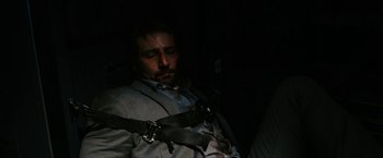 Movie still from “7500” (2019), directed by Patrick Vollrath – A man in a restraint belt is sleeping; Medium shot, High angle