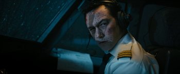 Movie still from “7500” (2019), directed by Patrick Vollrath – A man in a uniform with a headset on; Close Up shot, Overhead angle