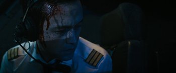 Movie still from “7500” (2019), directed by Patrick Vollrath – A person wearing a uniform with blood on his face; Close Up shot, Overhead angle