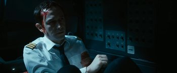 Movie still from “7500” (2019), directed by Patrick Vollrath – A man sitting in a car in a dark room; Medium shot, High angle