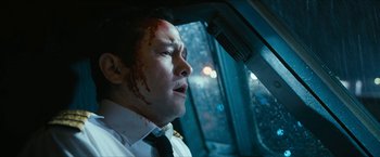 Movie still from “7500” (2019), directed by Patrick Vollrath – A man with blood all over his face looking out a window; Close Up shot, High angle