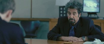 Movie still from “88 Minutes” (2007), directed by Jon Avnet – A man sitting at a wooden table with a cookie; Close Up shot, Over the shoulder angle