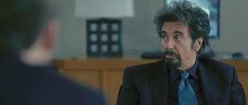 Movie still from “88 Minutes” (2007), directed by Jon Avnet – A man in a suit and tie sitting in front of a lamp; Close Up shot, Over the shoulder angle