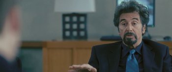 Movie still from “88 Minutes” (2007), directed by Jon Avnet – A man in a suit is sitting in front of a lamp; Close Up shot, Over the shoulder angle