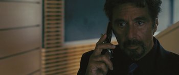 Movie still from “88 Minutes” (2007), directed by Jon Avnet – A man talking on a cell phone in a dark room; Close Up shot, Over the shoulder angle