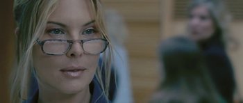 Movie still from “88 Minutes” (2007), directed by Jon Avnet – A person wearing glasses and a blue shirt; Close Up shot, Over the shoulder angle