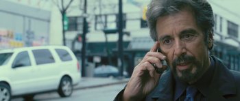 Movie still from “88 Minutes” (2007), directed by Jon Avnet – An older man talking on a cell phone while standing on the side of the road; Close Up shot, Over the shoulder angle