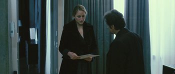 Movie still from “88 Minutes” (2007), directed by Jon Avnet – A woman in a black jacket is holding a piece of paper; Medium shot, Over the shoulder angle