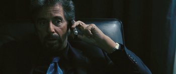 Movie still from “88 Minutes” (2007), directed by Jon Avnet – An older man talking on a cell phone while sitting in a chair; Close Up shot, Over the shoulder angle