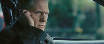 Movie still from “88 Minutes” (2007), directed by Jon Avnet – An older man sitting in the drivers seat of a car while talking on a cell phone; Close Up shot, Low angle