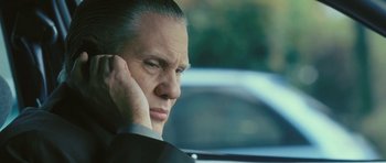 Movie still from “88 Minutes” (2007), directed by Jon Avnet – A person wearing a suit and holding his hand to his ear; Close Up shot, Low angle