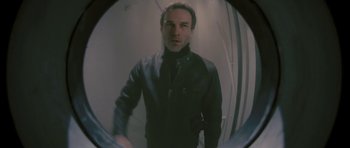Movie still from “88 Minutes” (2007), directed by Jon Avnet – A man in a black jacket is looking into a mirror; Medium shot, Low angle