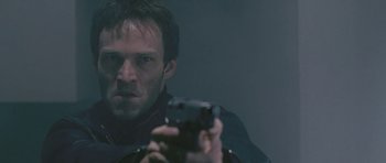 Movie still from “88 Minutes” (2007), directed by Jon Avnet – A man holding a gun in front of a mirror; Close Up shot, Low angle