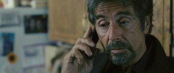 Movie still from “88 Minutes” (2007), directed by Jon Avnet – An older man talking on a cell phone while sitting down; Close Up shot, Over the shoulder angle