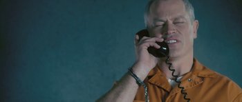 Movie still from “88 Minutes” (2007), directed by Jon Avnet – A man in an orange shirt talking on a phone; Close Up shot, Overhead angle