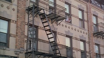 Movie still from “A Bronx Tale” (1993), directed by Robert De Niro – A fire escape on the side of an apartment building; Wide shot, Low angle