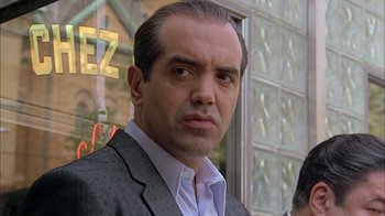 Movie still from “A Bronx Tale” (1993), directed by Robert De Niro – A person wearing a suit and tie; Close Up shot, Over the shoulder angle
