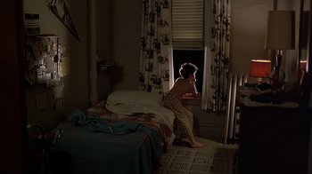 Movie still from “A Bronx Tale” (1993), directed by Robert De Niro – A woman standing in front of a window in a room; Wide shot, High angle