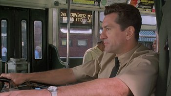 Movie still from “A Bronx Tale” (1993), directed by Robert De Niro – A man sitting on a bus with his hand on the steering wheel; Close Up shot, Low angle
