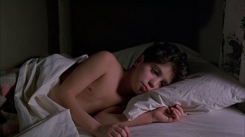 Movie still from “A Bronx Tale” (1993), directed by Robert De Niro – A boy laying in a bed with a white sheet; Close Up shot, High angle