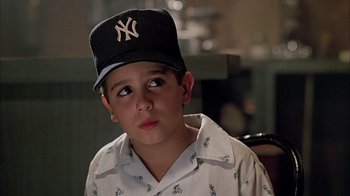Movie still from “A Bronx Tale” (1993), directed by Robert De Niro – A young boy wearing a new york yankees hat; Close Up shot, High angle
