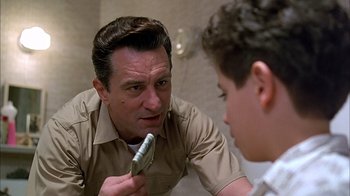 Movie still from “A Bronx Tale” (1993), directed by Robert De Niro – A man is looking at a boy in the mirror while he shaves his beard; Close Up shot, Low angle