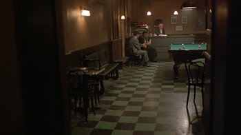 Movie still from “A Bronx Tale” (1993), directed by Robert De Niro – A group of people sitting at a table in a room; Wide shot, High angle