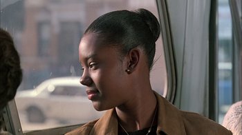 Movie still from “A Bronx Tale” (1993), directed by Robert De Niro – A young woman sitting in a car looking out the window; Close Up shot, Over the shoulder angle